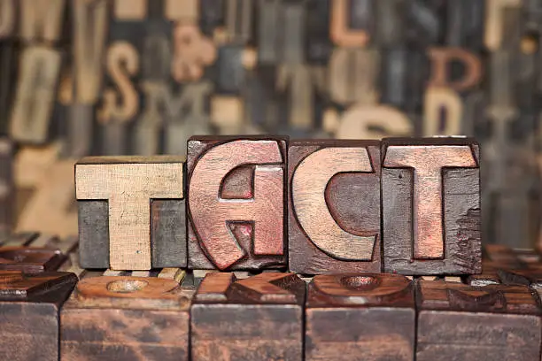 TACT word made from wooden letterpress blocks on many different letters background