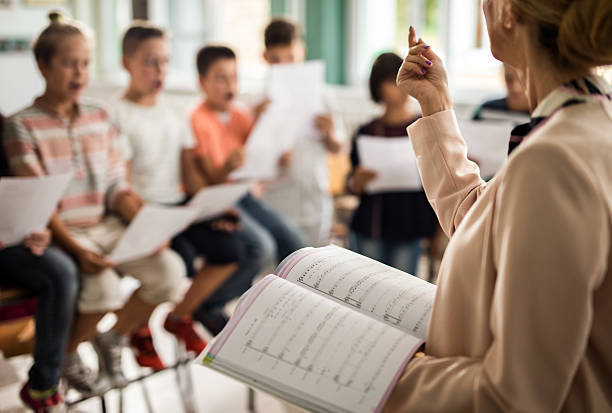 unkenntlich, dass der lehrer während des musikunterrichts eine lektion erteilt. - sheet music music classroom education stock-fotos und bilder