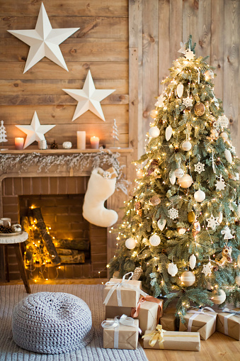 Christmas tree with vintage decorations near fireplace