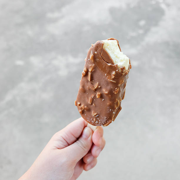 istock Hands holding vanilla icecreams covered with chocolate and almon 627503454