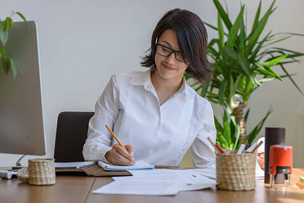 istock Woman writing sitting at her desk 627510206