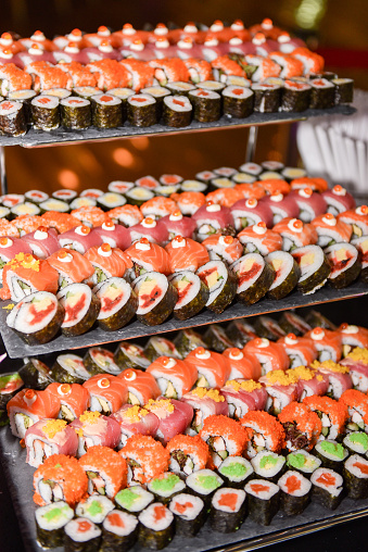 Different varieties of sushi on a platter. Display in buffet restaurant. Traditional Japanese Food.