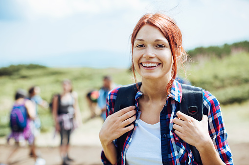 Close up of a smiling backpacker in the mountain, with copy space.