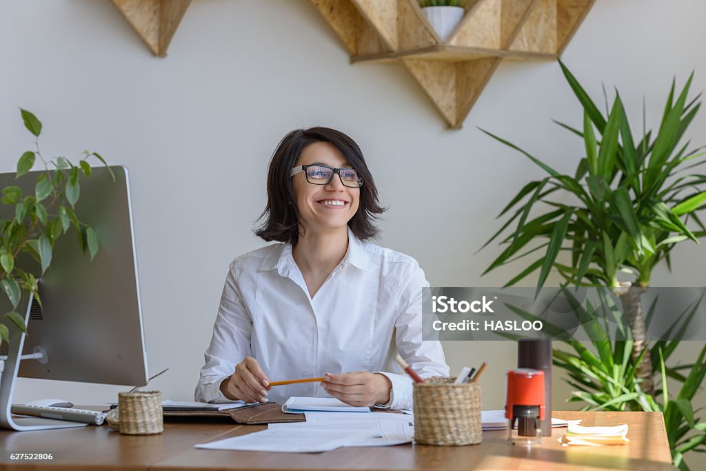 Cheerful happy woman working at office Woman smiling at office during working day Adult Stock Photo