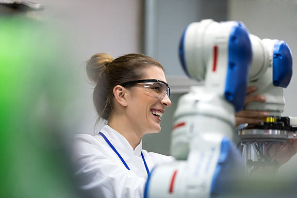 ingegneri donne che lavorano allo sviluppo di braccio robotico - research smiling scientist women foto e immagini stock