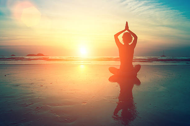 istock Woman practicing meditation near the ocean. 627539818