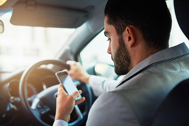 la conducción distraída puede aumentar la posibilidad de un accidente de tráfico - driving text messaging telephone mobile phone fotografías e imágenes de stock
