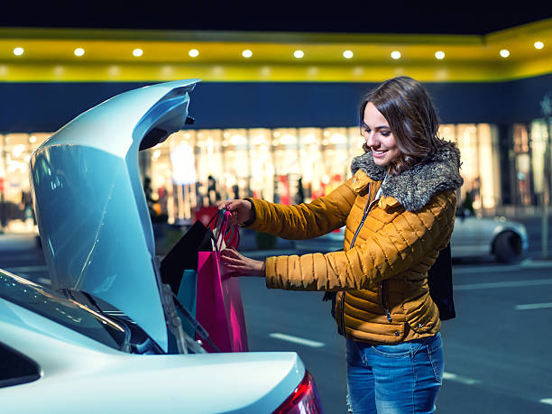 Woman putting shopping bags in the car stock photo