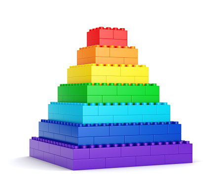 Rainbow pyramid made of plastic toy blocks isolated on white background. 3D illustration