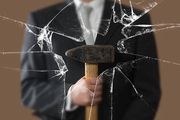 istock Business Man with Sladgehammer behind a broken Window 627541716