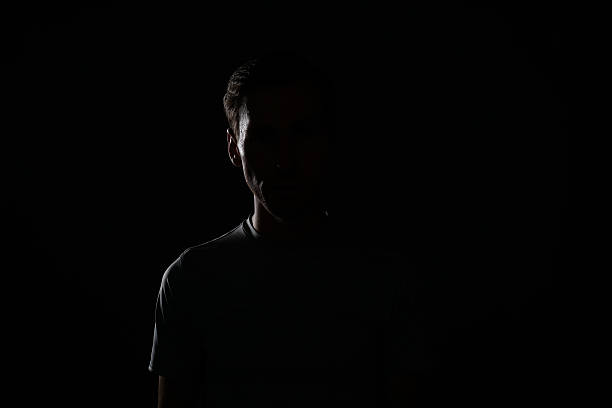 istock Young man in t-shirt on dark background. 627542478