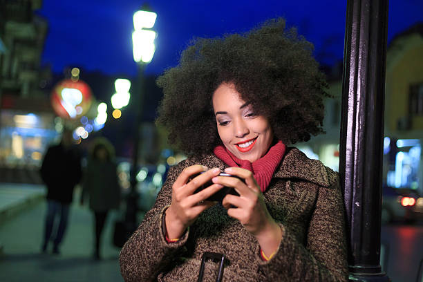 istock African woman using smart phone on street at night 627542970