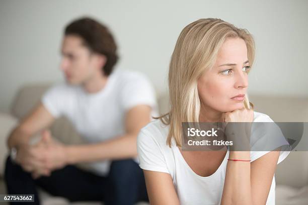 Sad Woman Thinking Over A Problem Man Sitting Aside Stock Photo - Download Image Now