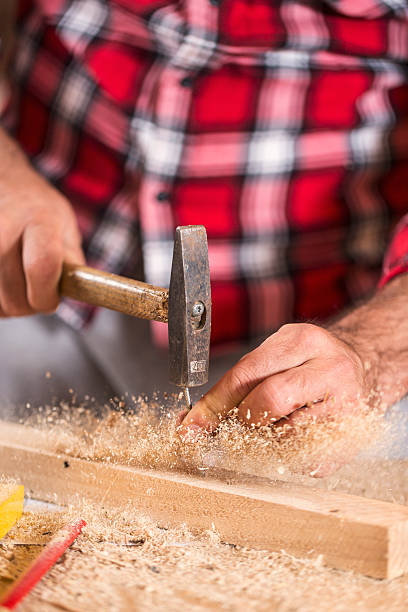 istock Hammering a nail into wooden board. Close up 627557814