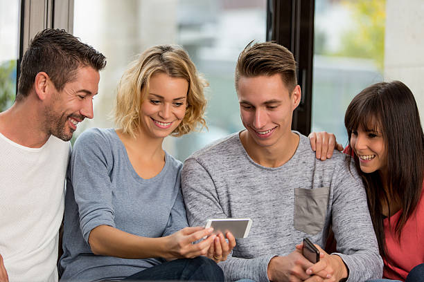 istock friends with smartphones on the sofa 627558786