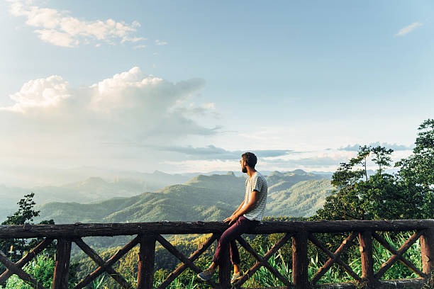 Man in mountains at sunset in Thailand Man on the background of beautiful sunset over green mountain hills in North of Thailand male meaning stock pictures, royalty-free photos & images