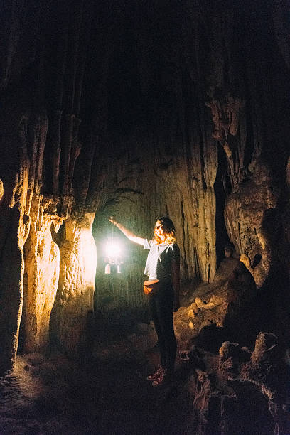 istock Woman standing in the cave with lantern 627575286