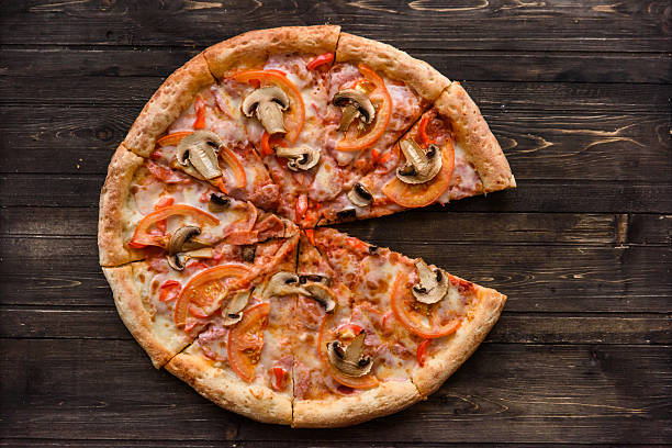 istock Pizza with salami, pickles, tomatoes, cheese and ham on a 627581778
