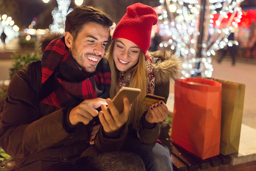 Happy couple shopping online christmas presents with credit card