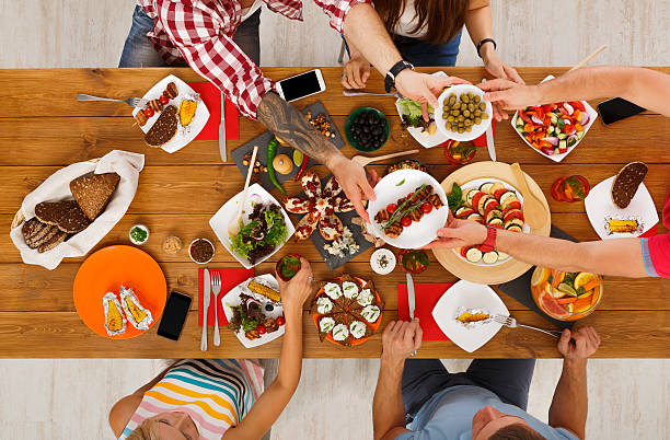 istock People eat healthy meals at festive table dinner party 627584230