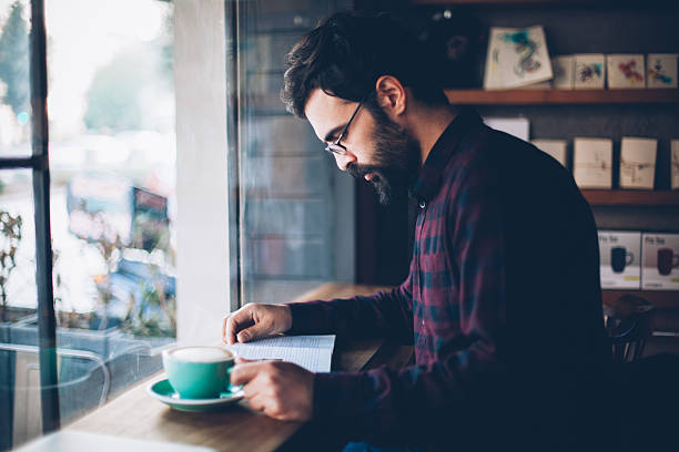 istock Reading a book at coffee shop 627584902