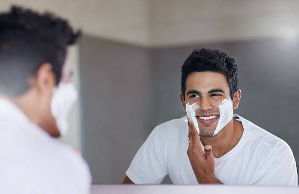 Sprucing up before a big date Shot of a handsome young man shaving his facial hair in the bathroom shaving stock pictures, royalty-free photos & images