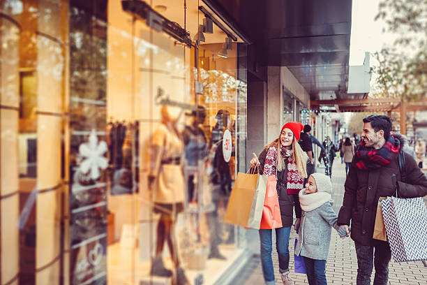 giovane famiglia che fa shopping per natale - christmas shopping foto e immagini stock