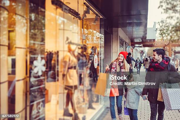 Young Family Shopping For Christmas Stock Photo - Download Image Now - Shopping, Retail, Vacations