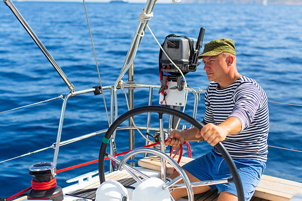 istock Man sits at the helm on the sailing boat. 627586936