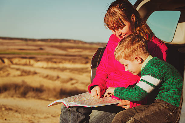 istock mother and son looking at map while travel by car 627587236