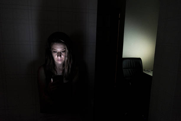 istock Sad woman sitting alone in her living room using smartphone 627587404