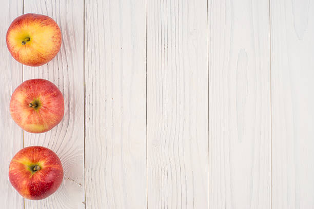 istock Red apples on the old wooden table. 627626862