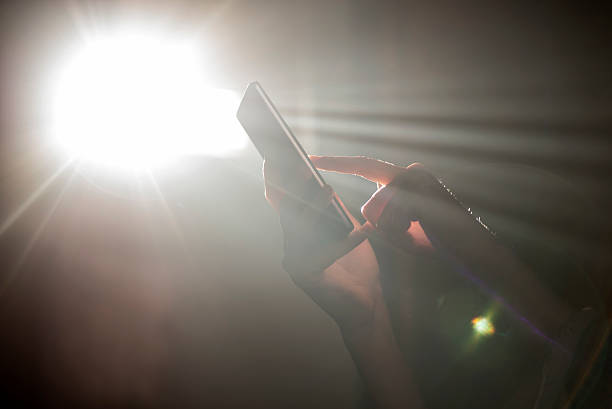 istock Hands hodling mobile phone with Sunshine through a window 627627560