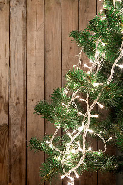 istock Christmas tree with lights on the wooden background 627627768