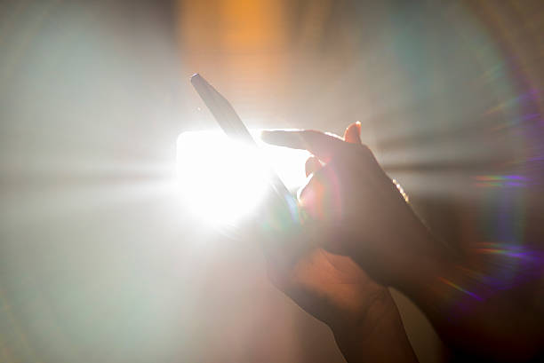 istock Hands holding smartphone with Sunshine in window 627627872