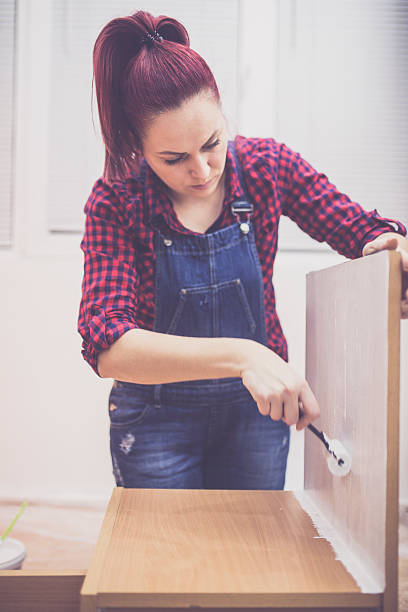 istock Woman with a paint roller, painting a home interior 627645060