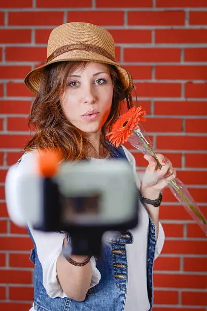 Photo of Woman taking selfie in front of brick wall