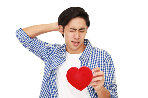 Depressed Asian man with a red heart