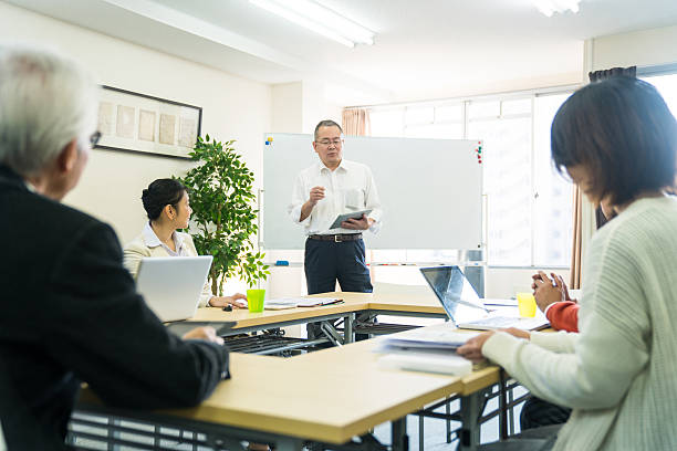 Teacher with adult students in community college stock photo