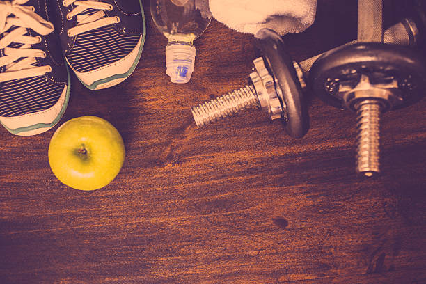 istock Fitness, exercise themed scene with barbells, sneakers, apple. 627678626