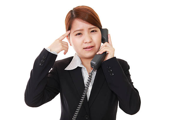 A relieved young businessman rubbing his face while taking a call