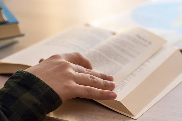 istock Reading a Book. Young Boy Sitting on Table at Home. 627682098