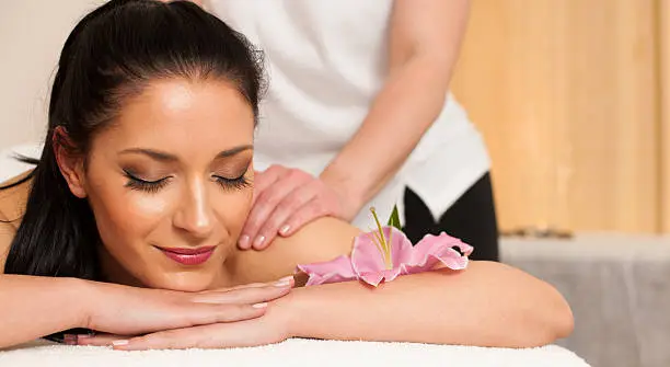 Beautifulyoung woman having a rejuvenating massage in a wellness studio - spa