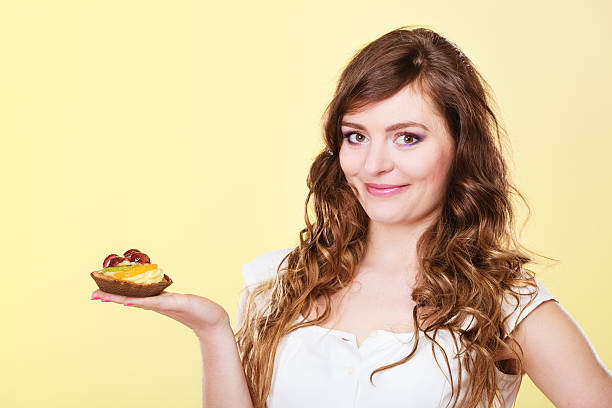 istock Smiling cute woman holds fruit cake in hand 627713452