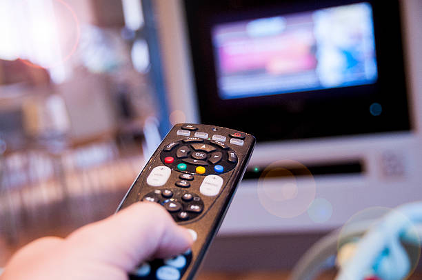 In control Man watching television using TV remote control control point stock pictures, royalty-free photos & images