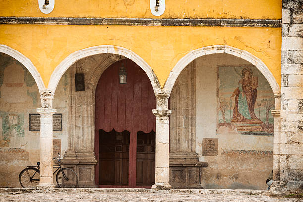 Curved arched architecture with pillars on old ancient stucco walls in the golden yellow Colonial town of Izamal, Yucatan, Mexico