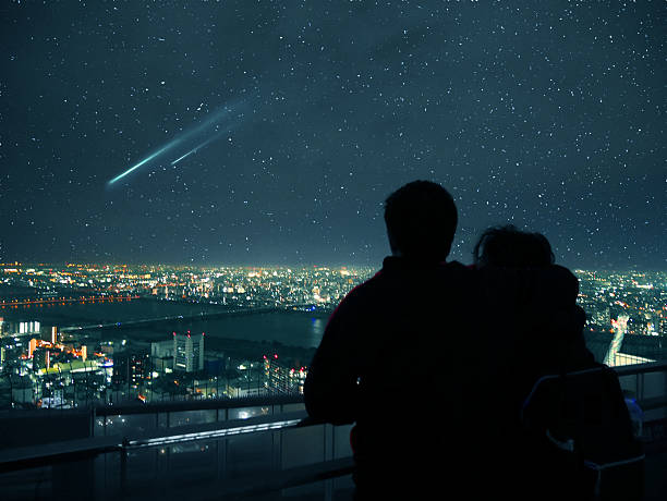 Couple looking over Osaka night skyline and falling stars