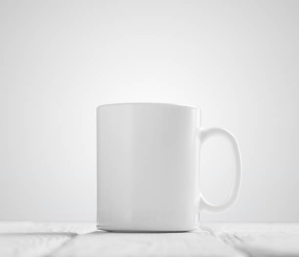 istock White cup mock-up inclined on wooden table 627725504