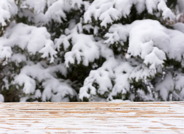 istock empty wooden table on a background of snow-covered trees 627725890