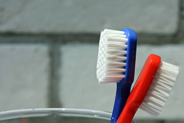 istock Male and female toothbrush standing back to back 627729120